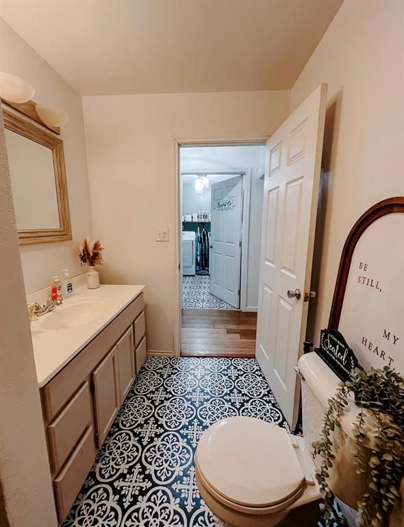 bathroom featuring toilet, hardwood / wood-style flooring, washer / dryer, and vanity