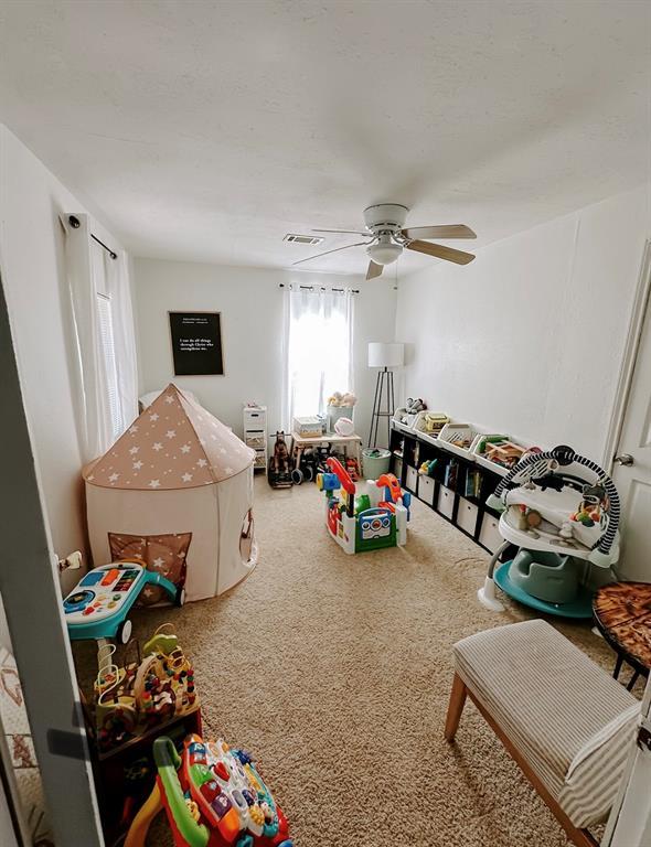 rec room featuring ceiling fan and carpet