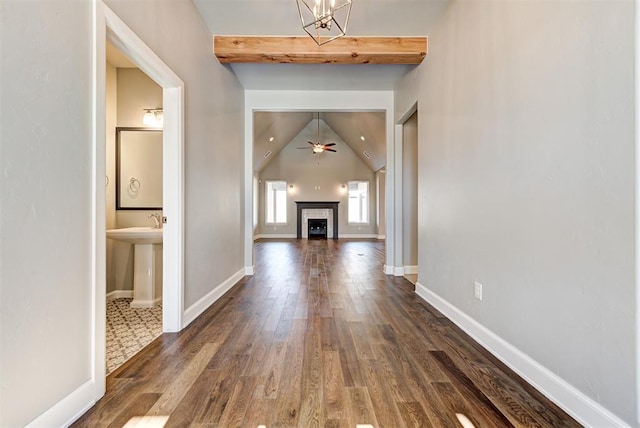 hallway with an inviting chandelier, dark hardwood / wood-style floors, and lofted ceiling with beams