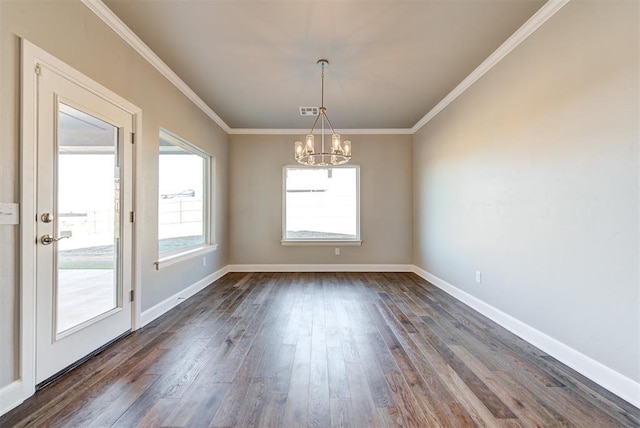 empty room with a notable chandelier, dark hardwood / wood-style flooring, and ornamental molding