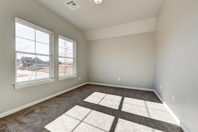 carpeted spare room with vaulted ceiling