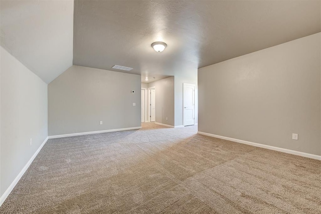 bonus room featuring vaulted ceiling and carpet