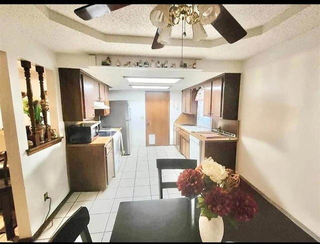 kitchen with ceiling fan, sink, light tile patterned flooring, and a textured ceiling