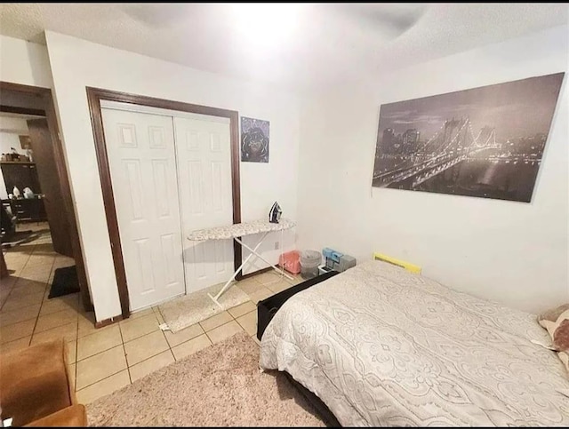 tiled bedroom featuring a textured ceiling, ceiling fan, and a closet