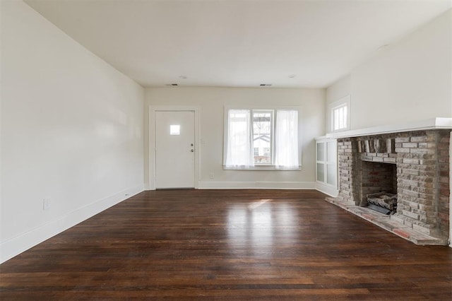 unfurnished living room featuring dark wood-type flooring and a fireplace