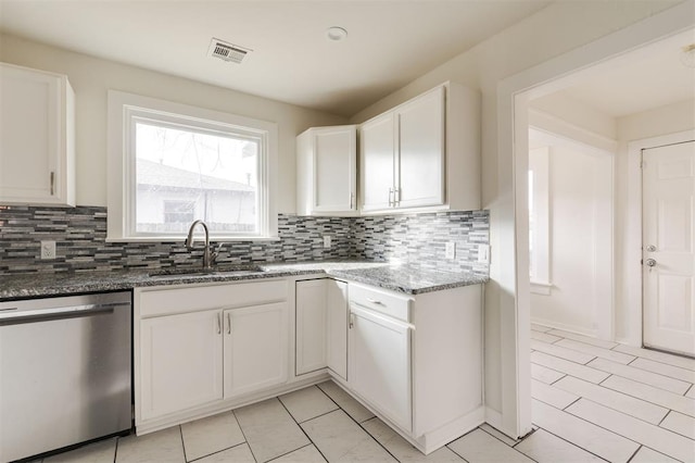 kitchen with white cabinetry, stainless steel dishwasher, sink, and dark stone countertops