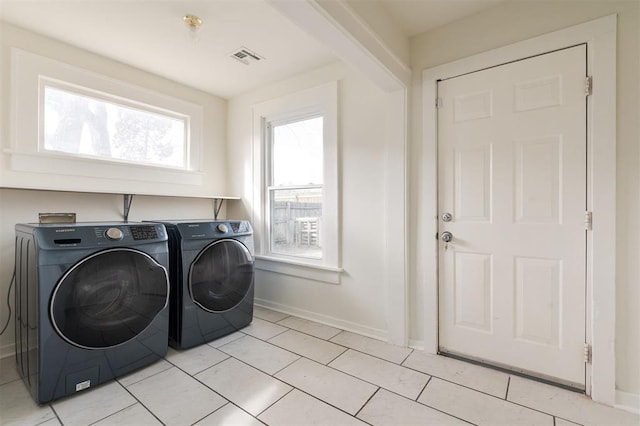 laundry area featuring light tile patterned flooring and separate washer and dryer