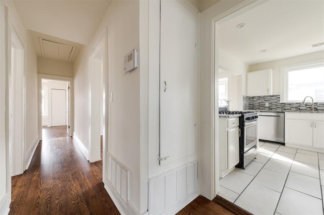 hallway featuring sink and light hardwood / wood-style floors