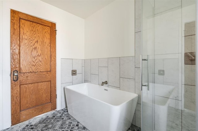 bathroom featuring tile walls and shower with separate bathtub