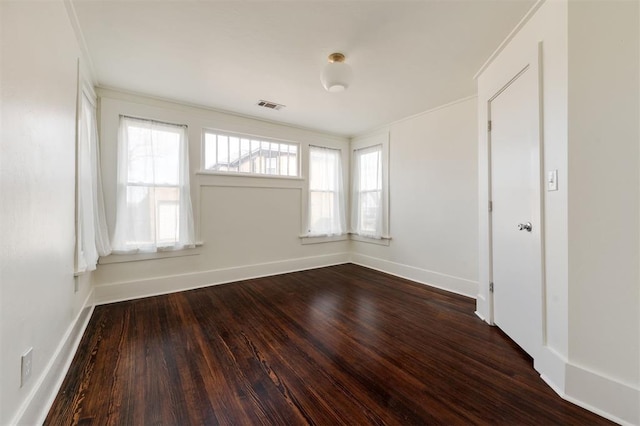 empty room with ornamental molding and hardwood / wood-style floors