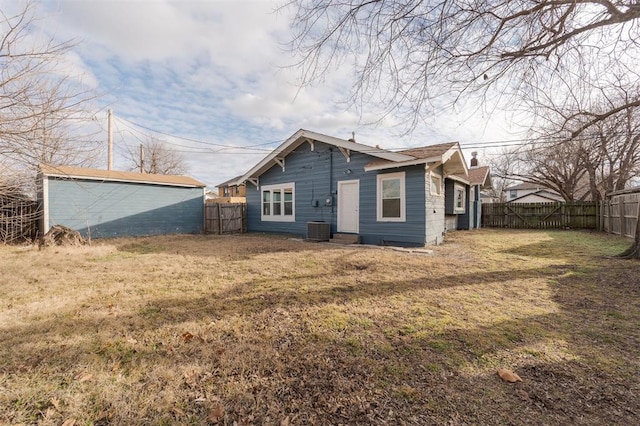 back of property featuring cooling unit and a lawn