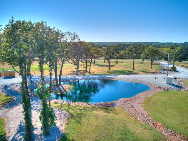 view of pool featuring a water view and a yard