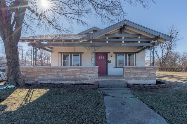 view of front of property featuring covered porch and a front yard