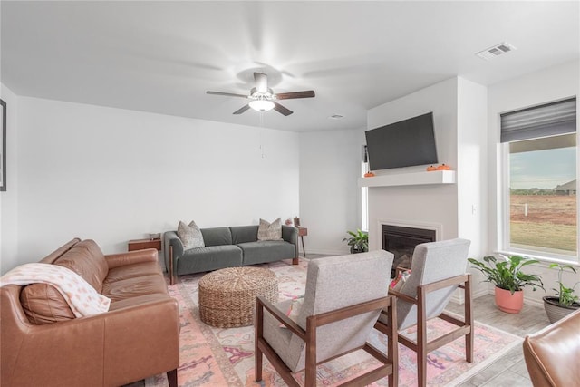 living room with ceiling fan and light wood-type flooring