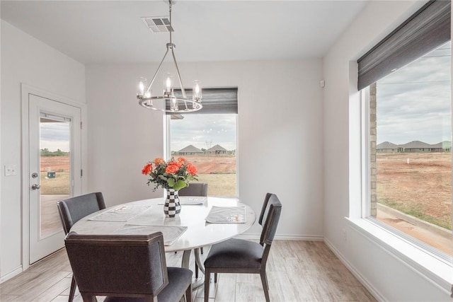 dining room featuring light wood-type flooring and a chandelier