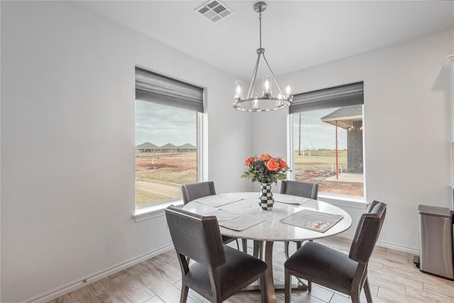 dining area with a chandelier and light hardwood / wood-style flooring