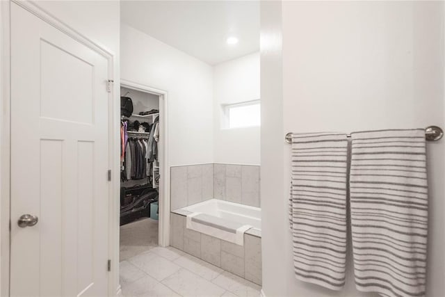 bathroom with tile patterned floors and tiled tub