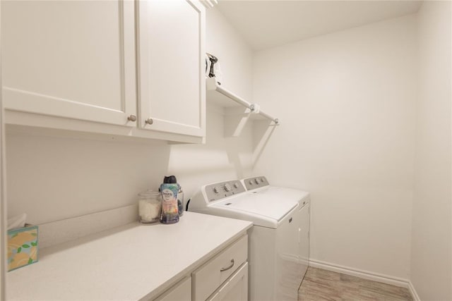 laundry room with washing machine and dryer and cabinets