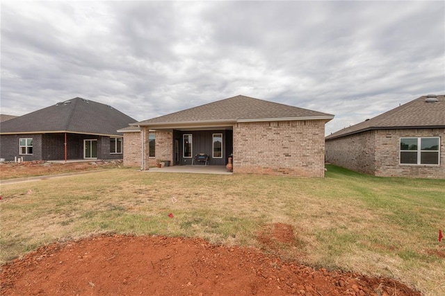 rear view of property with a lawn and a patio