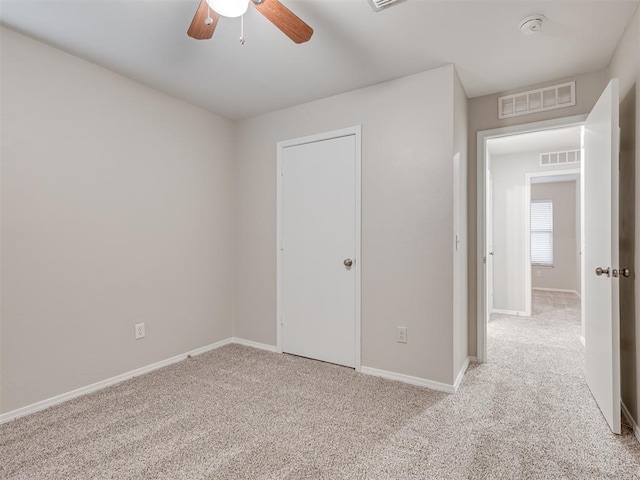 unfurnished bedroom featuring ceiling fan and light carpet