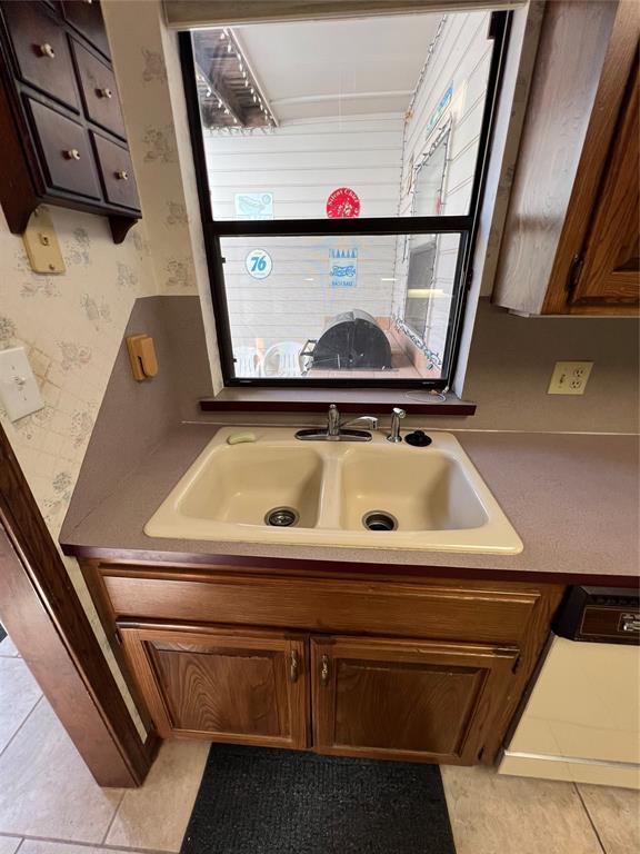 bathroom featuring wallpapered walls, plenty of natural light, tile patterned flooring, and vanity