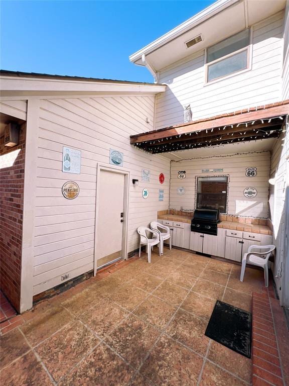 back of house with a patio area and brick siding