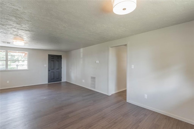 unfurnished room featuring a textured ceiling and dark hardwood / wood-style floors