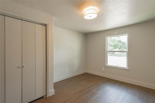 unfurnished bedroom featuring a closet and hardwood / wood-style floors