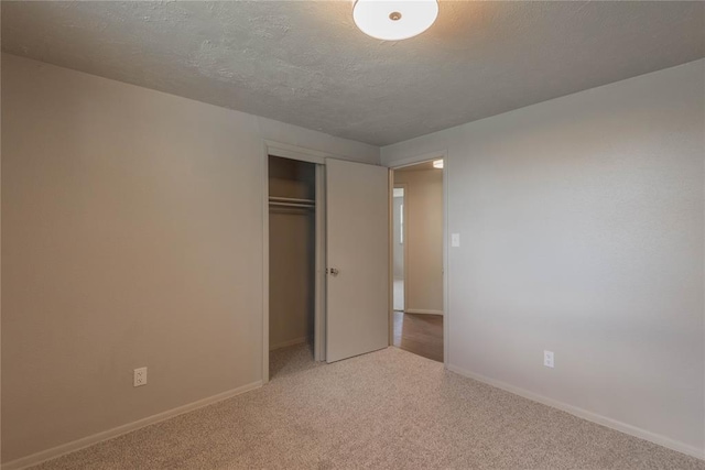 unfurnished bedroom featuring carpet floors, a closet, and a textured ceiling