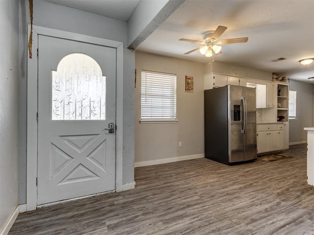 interior space with ceiling fan, white cabinets, stainless steel fridge, and plenty of natural light