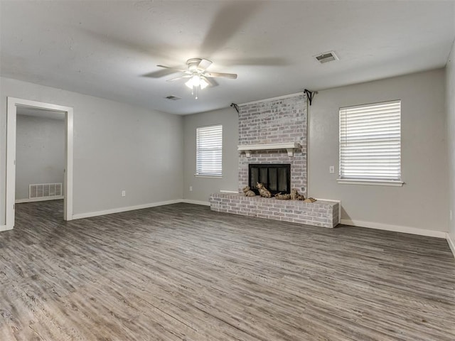 unfurnished living room featuring ceiling fan, a fireplace, and hardwood / wood-style floors