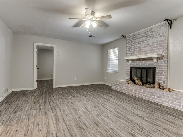 unfurnished living room featuring a brick fireplace, hardwood / wood-style floors, and ceiling fan