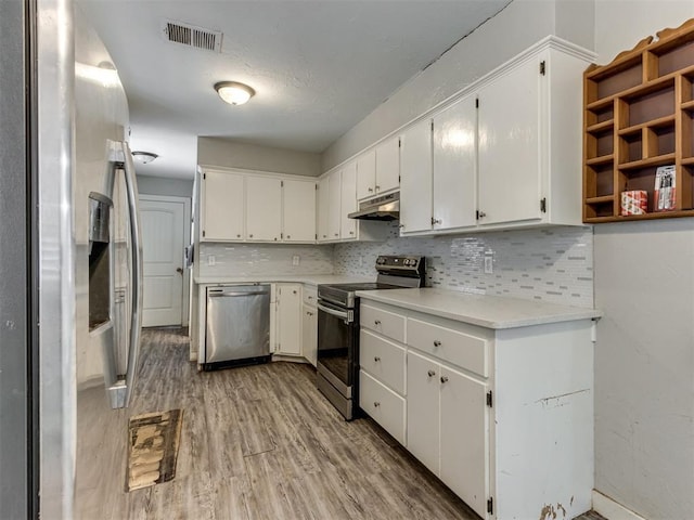 kitchen featuring light hardwood / wood-style flooring, backsplash, stainless steel appliances, and white cabinetry