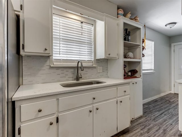 kitchen featuring white cabinetry, backsplash, stainless steel fridge, and sink