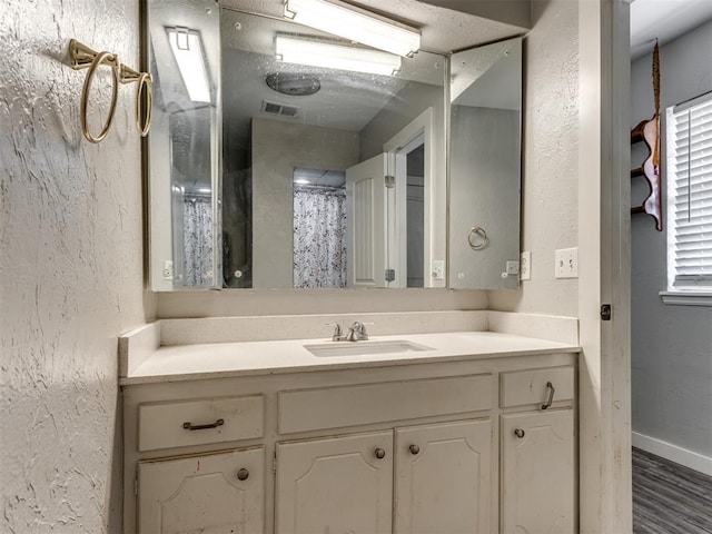 bathroom with a shower with curtain, hardwood / wood-style flooring, and vanity