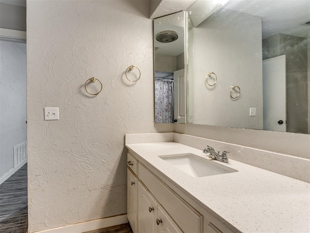 bathroom featuring wood-type flooring, vanity, and a shower with curtain