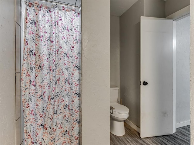 bathroom with hardwood / wood-style flooring and toilet