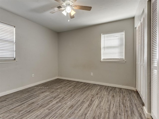 unfurnished bedroom with ceiling fan, wood-type flooring, and a closet