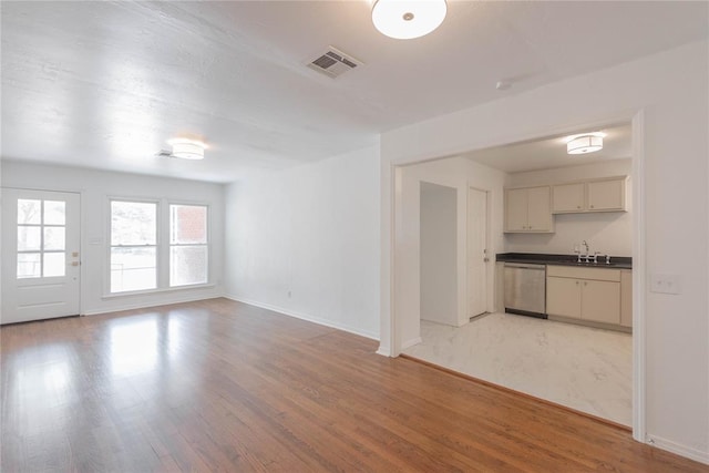 unfurnished living room featuring light hardwood / wood-style flooring and sink