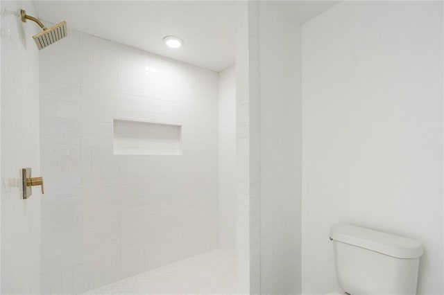 bathroom featuring toilet and tiled shower