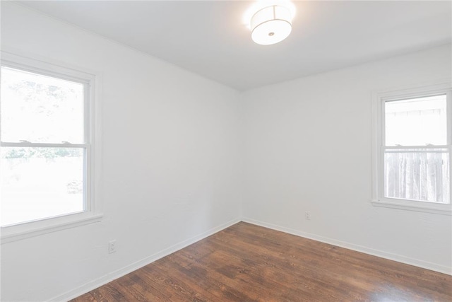 unfurnished room with dark wood-type flooring and a wealth of natural light