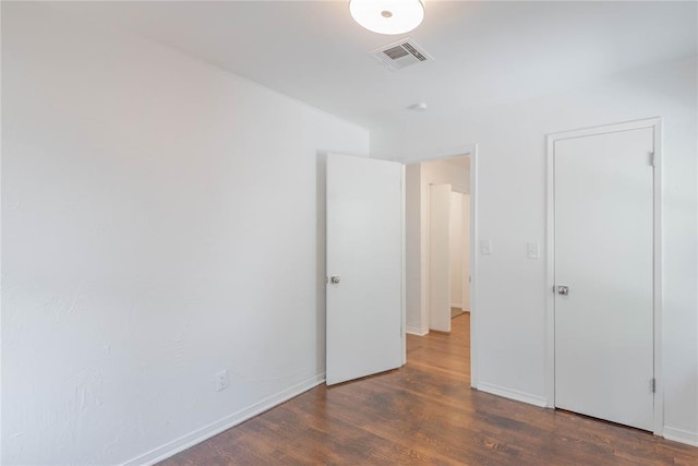 unfurnished bedroom with dark wood-type flooring