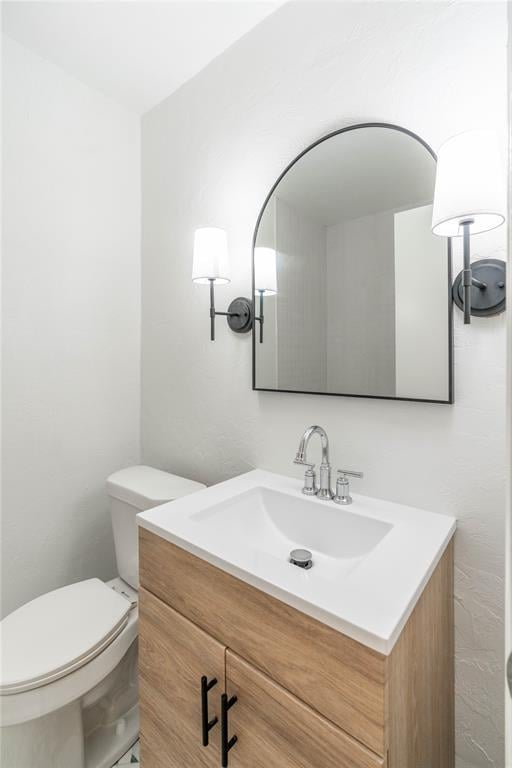 bathroom featuring toilet and vanity