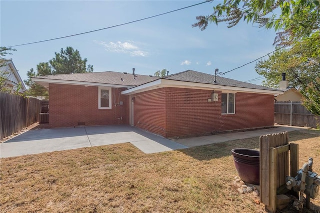 back of property with a patio area and a lawn