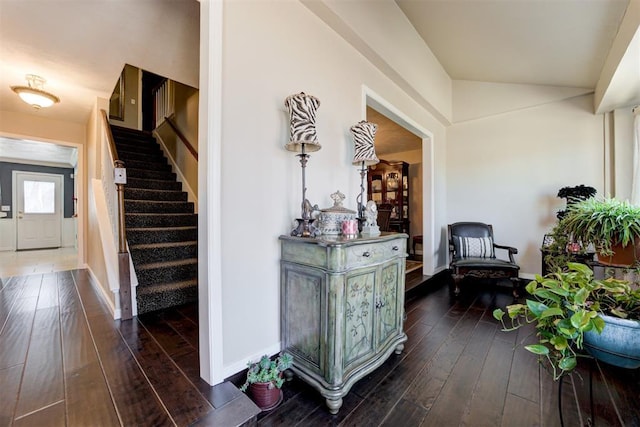 corridor with stairs, dark wood-type flooring, and baseboards