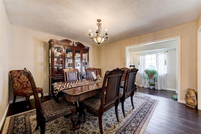 dining room featuring dark wood-type flooring and a chandelier