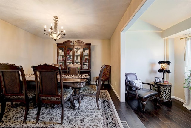 dining space with lofted ceiling, dark hardwood / wood-style flooring, and a chandelier