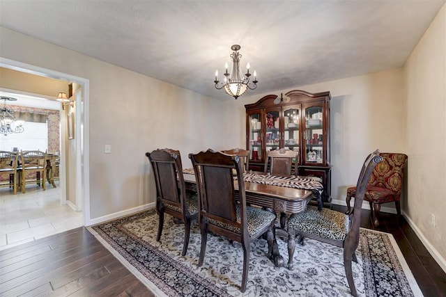 dining space featuring dark hardwood / wood-style floors and an inviting chandelier