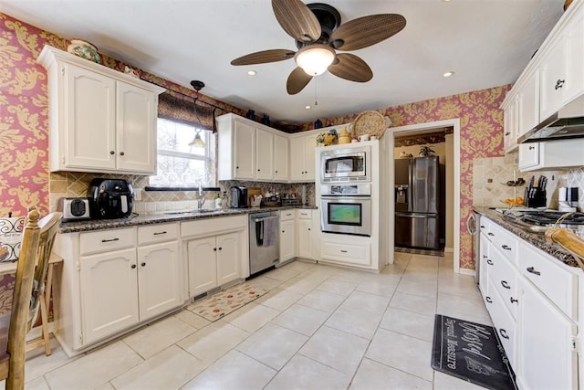 kitchen with ceiling fan, sink, dark stone countertops, and stainless steel appliances