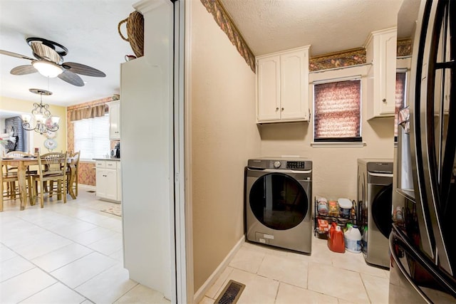 laundry room with washer and clothes dryer, light tile patterned flooring, a textured ceiling, cabinets, and ceiling fan with notable chandelier